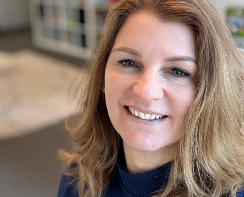 Coach kijkt vriendelijk in de camera